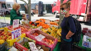 A woman buys produce from a market stall in York - 28 May 2020
