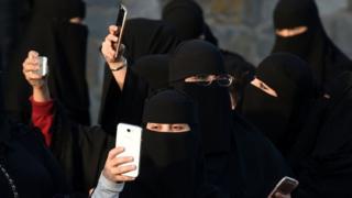 نساء سعوديات يلوحن بأجهزة المحمول