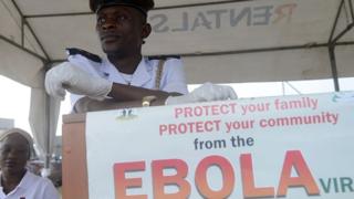 Медицинский работник ожидает проверки на наличие верных мусульманских верующих вируса Эбола во время паломничества в Мекку 19 сентября 2014 года в международном аэропорту Муртала Мухаммед в Лагосе.