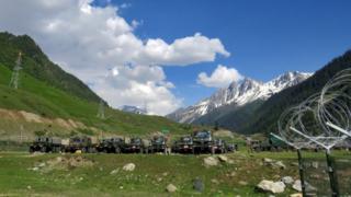 Soldados del ejército indio pasan junto a sus camiones estacionados en un campamento de tránsito improvisado antes de dirigirse a Ladakh, cerca de Baltal, al sureste de Srinagar, el 16 de junio de 2020