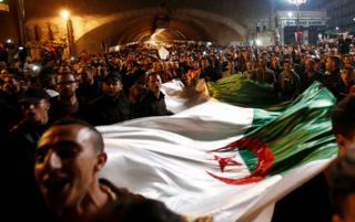 People carry a national flag as they celebrate on the streets after Algeria"s President Abdelaziz Bouteflika has submitted his resignation, in Algiers, Algeria, 2 April 2019.