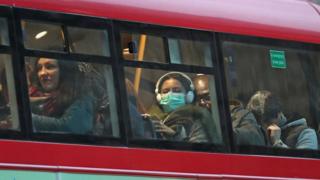 A woman wearing a face mask on a bus in London, as the first case of coronavirus has been confirmed in Wales and two more were identified in England