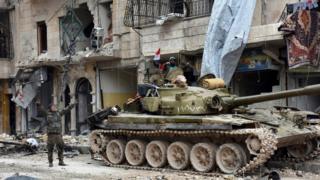 Syrian army soldiers make victory signs in the Sukkari district of Aleppo, Syria (23 December 2016)