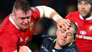Munster's Dave Kilcoyne is tackled by Paul James of Ospreys
