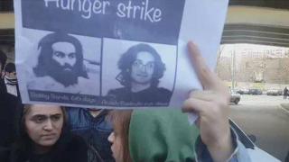 Woman holds poster with picture of Iranian activist Arash Sadeghi