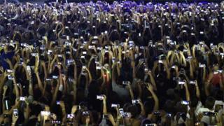 Fans use their phones at concert