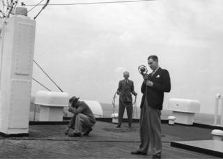 Picture shows messers Hall, Preston and Howard, outside broadcast engineers, on the raised sun deck.