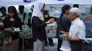 Warga membagikan mawar putih setelah umat Islam selesai salat Tarawih.
