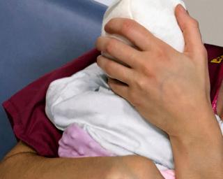 A doctor holds a newborn baby