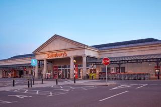 A view of the front of a Sainsbury's supermarket and an empty car park