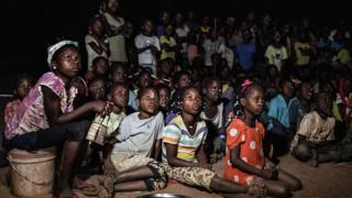 People watching a broadcast on a giant screen in Alua, Mozambique - Friday 6 July 2018