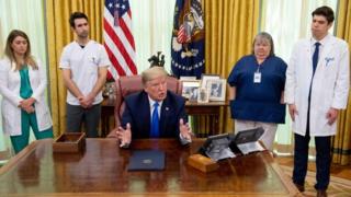 President Donald Trump in the Oval Office at the White House with nurses, 6 May 2020