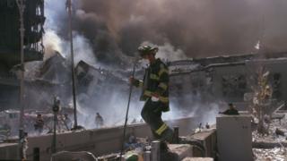 A firefighter walking through the rubble after 9/11