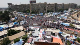 Hundreds of people gather on the cross section of two roads in Cairo in 2013