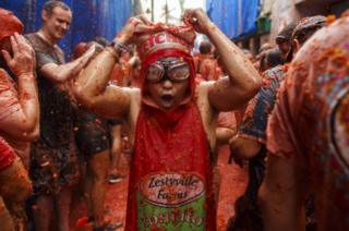 Revellers enjoy the atmosphere in tomato pulp while participating the annual Tomatina festival on 30 August 2017 in Bunol, Spain.