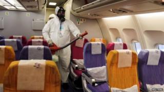 An official disinfects the cabin of an aircraft at Bangkok's airport