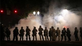 Federal law enforcement officers, deployed under the Trump administration's new executive order to protect federal monuments and buildings, face off with protesters in Portland