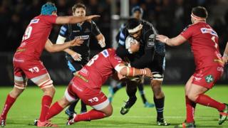 Glasgow Warriors' Brian Alainu'uese is held up by the Scarlets defence