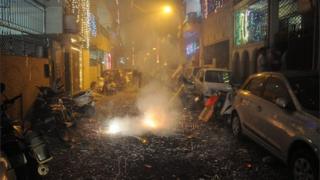 A picture made available on 31 October 2016 shows Indian people lighting firecrackers on a street littered with spent crackers during the Diwali festival celebrations near New Delhi, India, 30 October 2016.