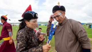 Juízes durante o festival Naadam na Mongólia cobrem seus rostos com telas protetoras, em julho de 2020.