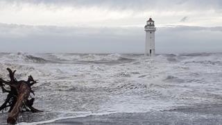 A lighthouse with waves on the beach