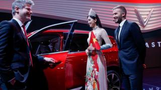 Giám đốc thiết kế của VinFast, Dave Lyon, cùng Hoa hậu Trần Tiểu Vy và cựu danh thủ David Beckham tại lễ ra mắt xe VinFast của Việt nam ở Hội chợ Motor Paris năm 2018 ở Parc des Expositions, Porte de Versailles hôm 02/10/2018