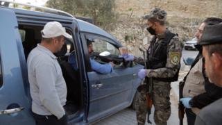 Palestinian security forces search a car near the West Bank town of Hebron to prevent workers crossing illegally into Israel