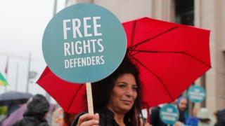 A woman holds a slogan that reads "Free rights defenders" outside Istanbul's court. Photo: 25 October 2017