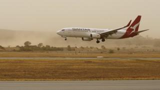 A plane lands at Canberra Airport amid thick bushfire smoke