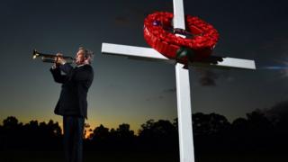 A music teacher plays the bugle at a Brisbane school in an Anzac Day preview ceremony