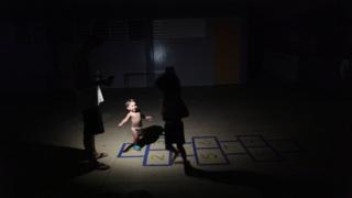 Un niño juega bajo la luz de una linterna en Puerto Rico.