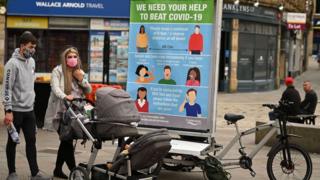A couple in Halifax, England on 9 August - where local lockdown restrictions are in effect