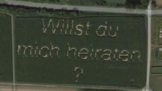 A screenshot from Google Maps shows the words "Willst du mich heiraten?" ("Do you want to marry me?") spelled out in a field of corn