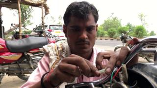 गाड़ी सही करता हुआ एक मैकेनिक