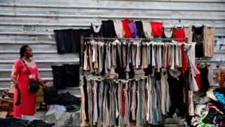 A woman waits for customers at a streetside boutique at the central business district in Nigeria's commercial capital Lagos
