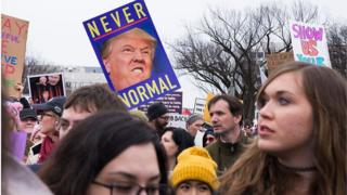 Manifestantes com cartaz contra Trump em Washington em 21 de janeiro