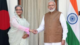 বাংলাদেশের প্রধানমনত্রী শেখ হাসিনা ভারতের প্রধানমন্দ্রী নরেন্দ্র মোদীর সাথে করমর্দন করছেন।
