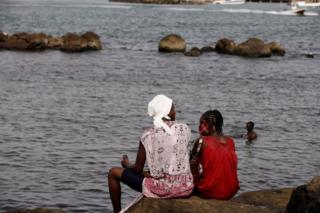 Women sit on a rock at a beach called "Plongeoir", amid the outbreak of the coronavirus disease (COVID-19) in Dakar, Senegal June 28, 2020.