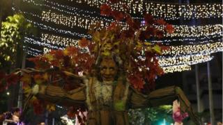An artist dressed as a tree takes part in a parade in Medellín
