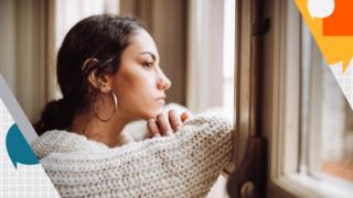 Pensive woman looking out of a window