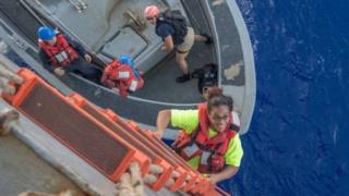 Una mujer subiendo por un barco