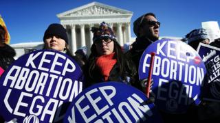 Pro-choice activists hold signs as marchers of the annual March for Life arrive in front of the US Supreme Court.