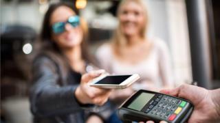 Un hombre pagando con contactless