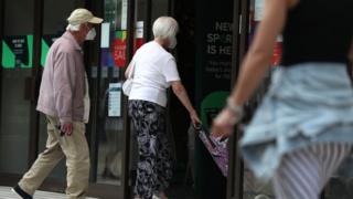 Couple with masks entering store