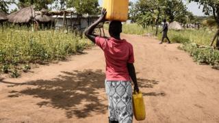 South Sudan refugee for Uganda dey carry water