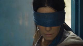 Star of di Bird Box feem, Sandra Bullock wey blindfold her eyes.