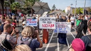 Imagem mostra mulheres segurando cartazes e sendo fotografadas em protesto realizado na cidade de Copenhague,no primeiro dia da implementação da proibição do véu no país