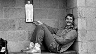 Nigel Mansell sheltering from the rain at Silverstone in 1985