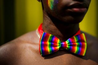 A man wears a rainbow bow tie