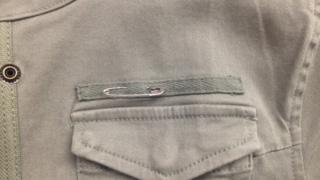 A picture of a safety pin on a jacket lapel.